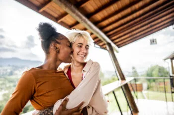 Young homosexual couple embracing on balcony